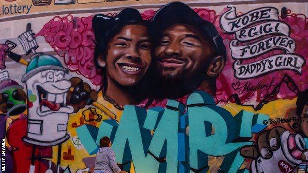 A mourner pays respects at a mural for Kobe Bryant and his daughter in LA