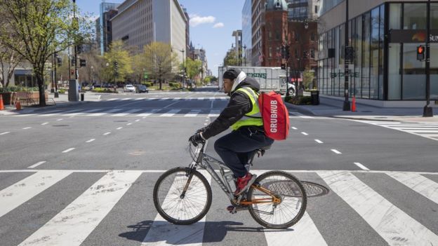 Grubhub delivery person Tayy Evans makes bicycle deliveries on the empty streets of Washington, DC, USA, 02 April 2020