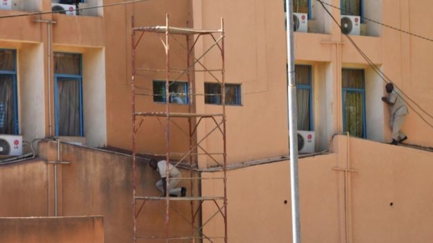 Men are seen escaping from the military HQ after it came under attack in Ouagadougou