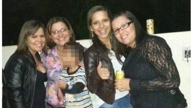 Mãe e filhas posam sorridente em foto