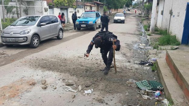 Policial destruindo barricada