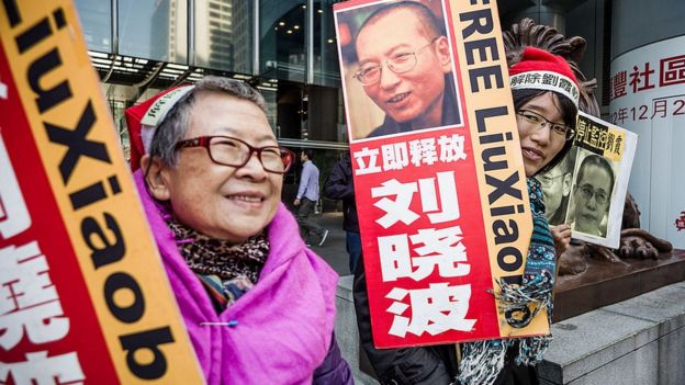 Members of the Hong Kong Alliance in Support of Patriotic Democratic Movements of China hold placards before they march to the central post office to mail a Christmas parcel to China's jailed Nobel Peace Prize laureate Liu Xiaobo, in Hong Kong on December 10, 2012