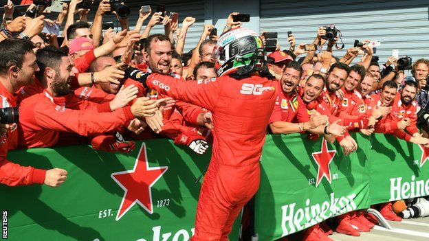 Charles Leclerc celebrates with the Ferrari pit crew
