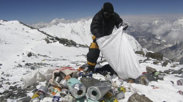 Nepalese sherpa picking up trash on Everest