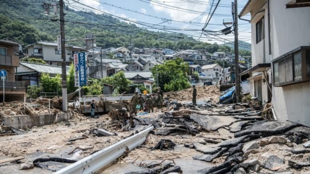 Soldiers work to clear a road following a landslide, on July 10, 2018 in Yanohigashi near Hiroshima, Japan