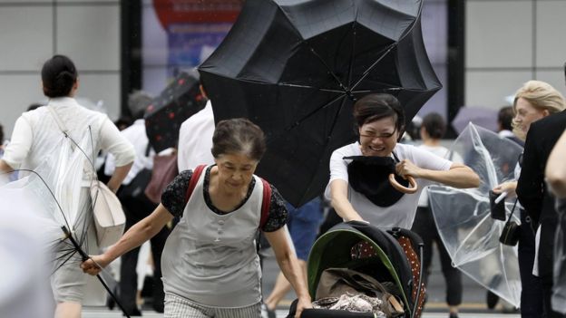 People with umbrellas walking through the storm