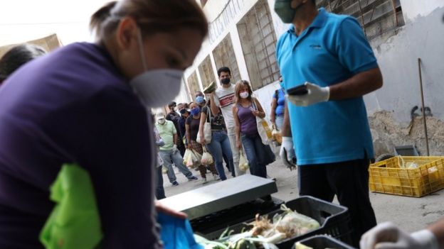 Personas hacen fila en Venezuela para comprar alimentos.