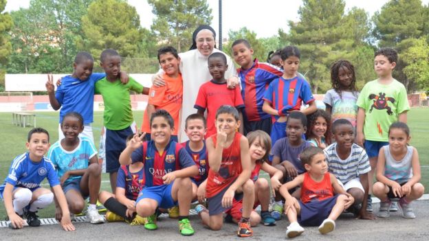 Sor Lucía rodeada de niños en un partido de fútbol.