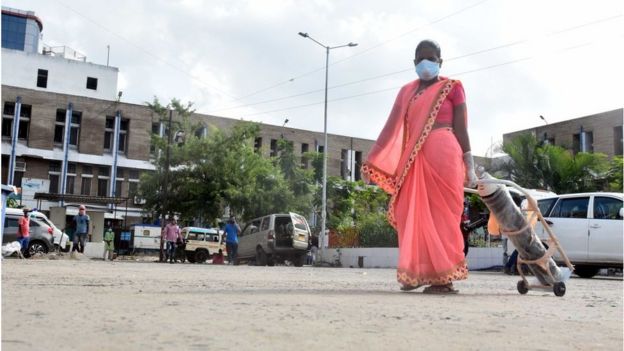 A woman carries an oxygen cylinder at Nalanda Medical College and Hospital campus on July 22, 2020 in Patna, India
