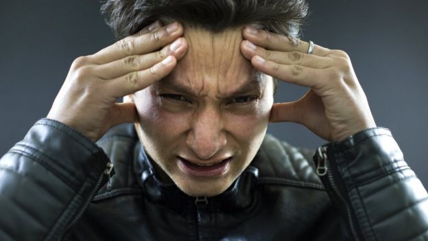 Hombre joven con manos en la cabeza.