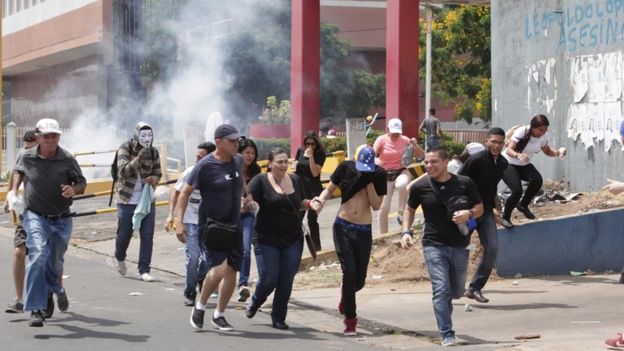 Manifestantes huyen de las bombas lacrimógenas durante protesta en Puerto Ordaz.