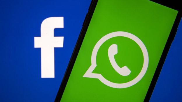 The Facebook and WhatsApp logos are seen on a phone in this photo illustration