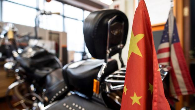 Chinese and US flags are seen on a Harley-Davidson motorcycle in the maintenance room of a dealership in Shanghai on August 24, 2018.