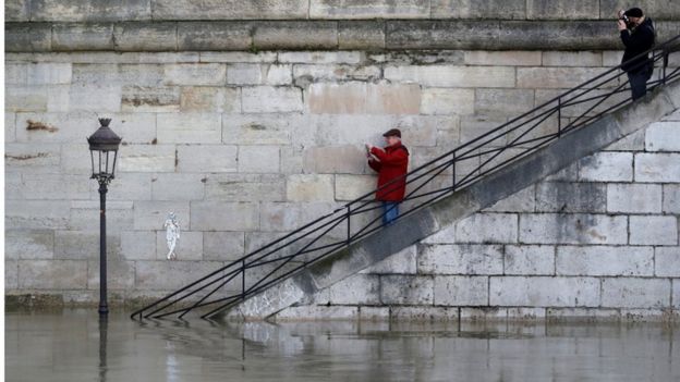 Two men on steps photograph flooding River Seine, Paris, 26 Jan 2018