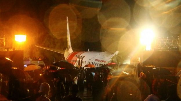 Rescue workers look for survivors after a passenger plane crashed when it overshot the runway at the Calicut International Airport