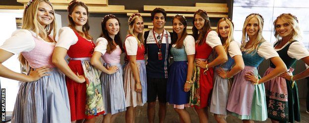 Lance Stroll poses with women in traditional Austrian clothing