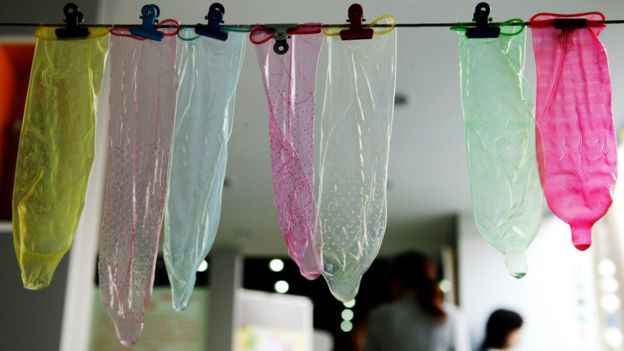 Condones en diferentes colores colgados en un tendedero en China