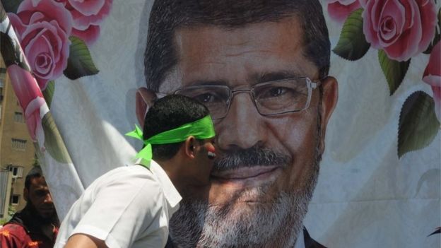 A supporter of Mohammed Morsi kisses his portrait in Cairo (21/06/13)
