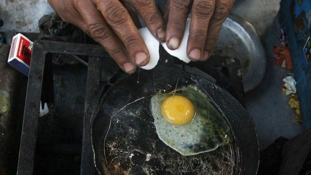 An Indian woman makes an omelette in Kolkata