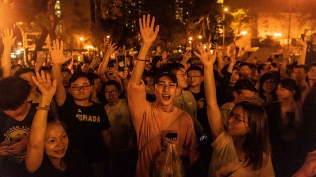 Jóvenes celebrando el triunfo de candidatos prodemocracia en Hong Kong.