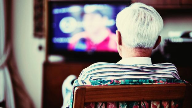 Hombre solitario viendo la televisión.