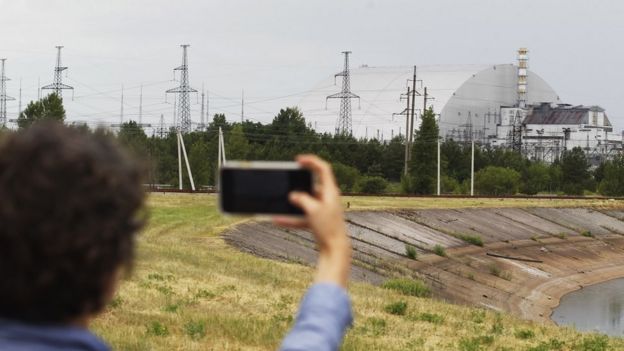 Un visitante toma fotografías del Nuevo Confinamiento Seguro que cubre el cuarto reactor de la planta nuclear de Chernóbil