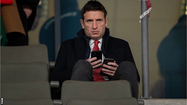Noel Mooney sat looking at two phones during Wales v ROI