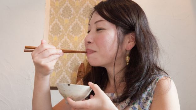 Jeune femme japonaise mangeant du riz