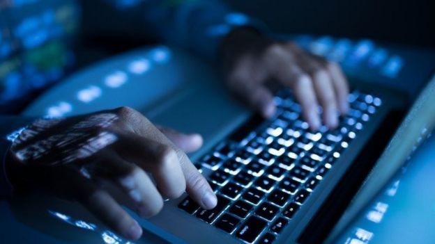 A person typing on a laptop computer