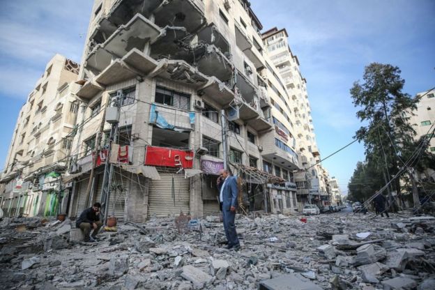 Dua orang warga Palestina memerik bangunan apartemennya yang rusak di Gaza City setelah serangan roket oleh militer Israel ke kawasn itu, Minggu, 5 Mei 2019. Mustafa Hassona/Anadolu Agency/Getty Images)