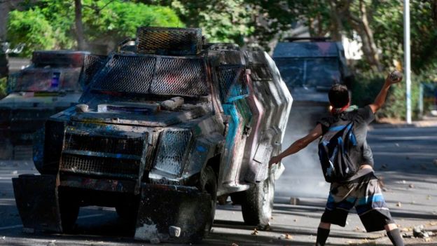 Manifestante frente a un tanque antidisturbios