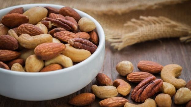 Pote com diversas frutas secas, como amêndoas e castanha de caju