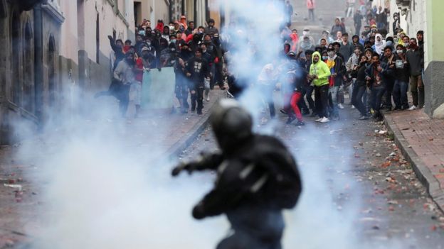 Un policía lanzando gases lacrimógenos a los manifestantes.