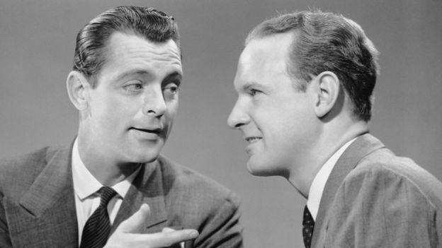 Dos hombres conversando en los 50.