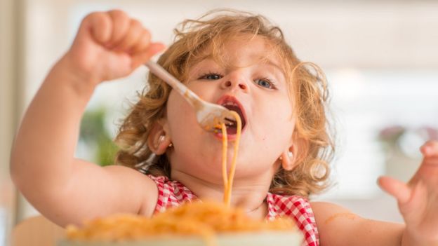 Niña comiendo pasta