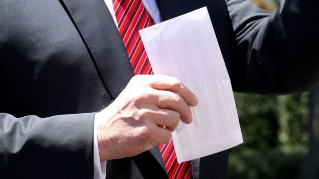 Donald Trump with Mexico immigration deal on sheet of paper