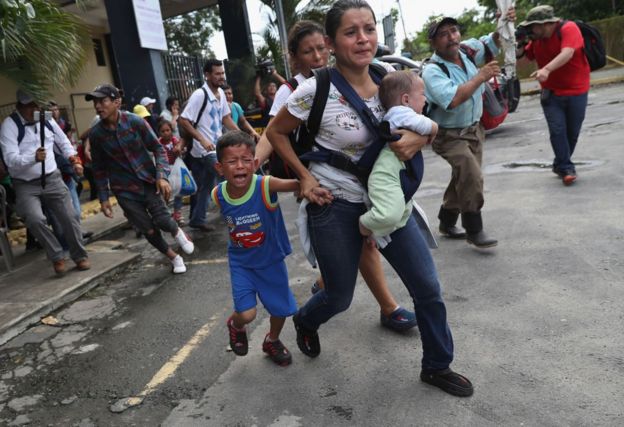 Mulher corre com os filhos em meio à confusão na fronteira entre México e Guatemala
