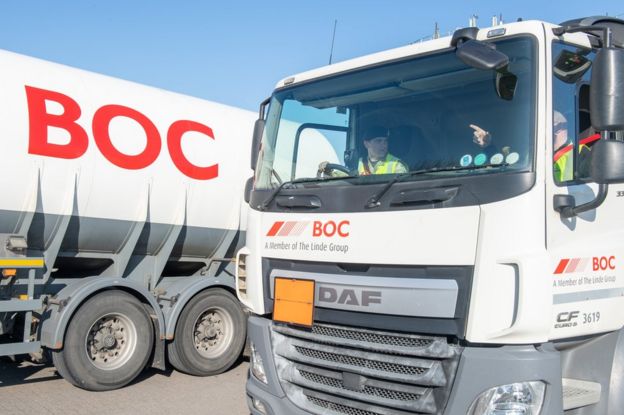 A soldier drives a lorry delivering oxygen to a hospital