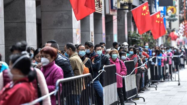 ciudadanos chinos hacen largas filas para comprar remedios y mascarillas.