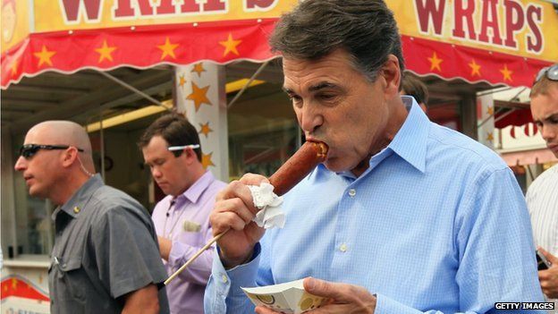 Governor Rick Perry eats a 'veggie' corn dog while visiting the Iowa State Fair
