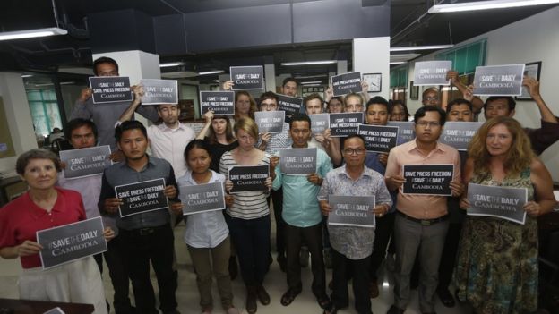 Cambodia Daily staff hold placards reading #SaveTheDaily