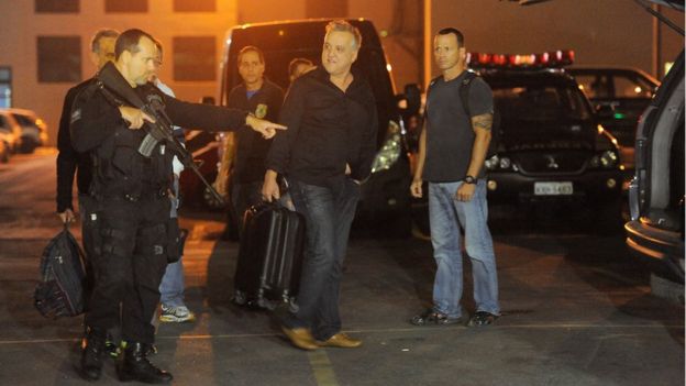 O empresário Carlinhos Cachoeira (ao centro), preso na Operação Saqueador, embarca na viatura da Polícia Federal após depoimento em 30/6/2016