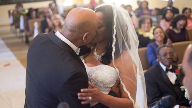 Cedric Anderson (L) kisses his wife Karen Smith (R) at their wedding on 28 January.