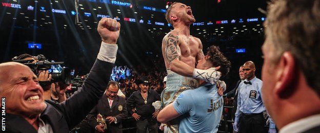 Barry McGuigan (left) celebrates as Frampton is hoisted into the air by trainer Shane McGuigan after his victory over Leo Santa Cruz in New York a year ago