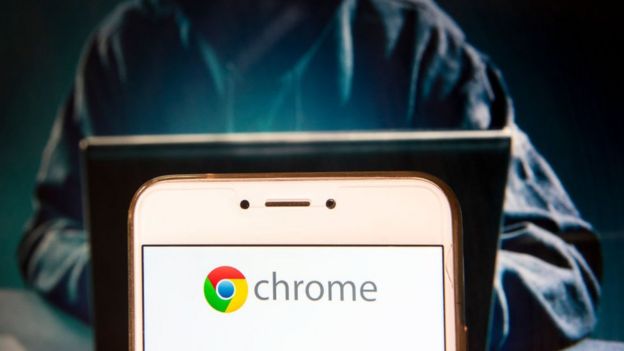 Pantalla de celular con el logo de Google Chrome y un hacker manejando una computadora.
