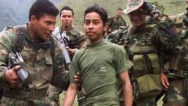 Soldiers escort a 13-year-old captured teenage rebel of the Farc in the mountains of Santander state on 21 December, 2000.