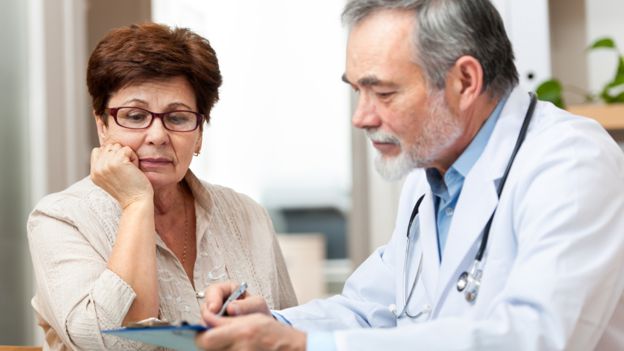 Mujer escuchando un médico durante una consulta