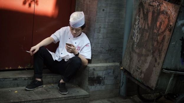 Пекин, Китай, работник ресторана отдыхает на перекуре