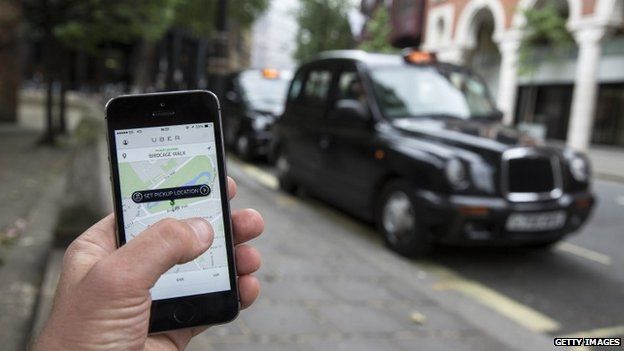 A smartphone displays the "Uber" mobile application which allows users to hail private-hire cars from any location