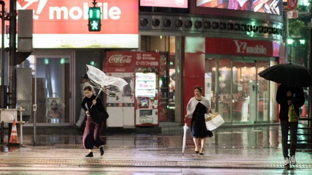 A woman protects herself from the rain with an umbrella in the streets of Tokyo on 30 September 2018